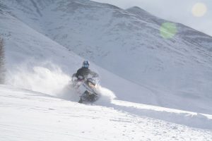 person snowmobiling on a mountain near leadville