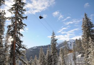 person ziplining in the mountains and snow at 11,200 feet elevation
